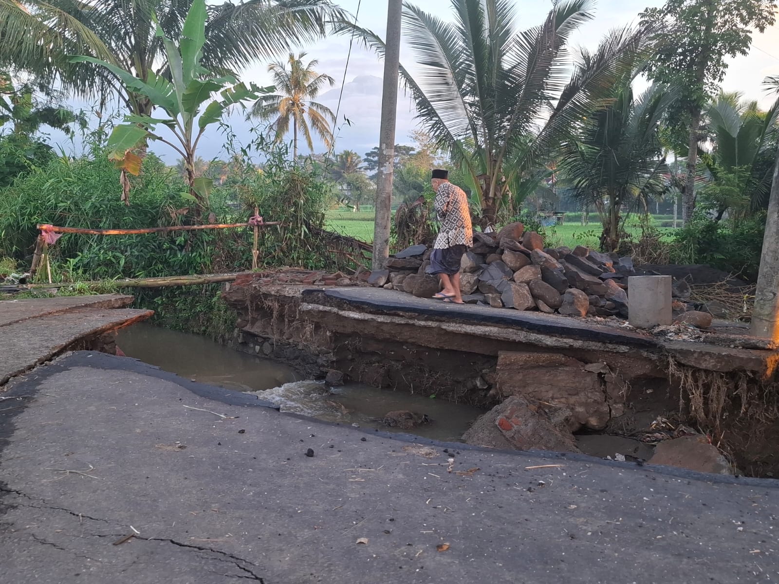 Seorang warga Desa Montong Betok saat melihat di jembatan penghubung antara Desa Montong Betok dengan Pringgajurang yang Putus
