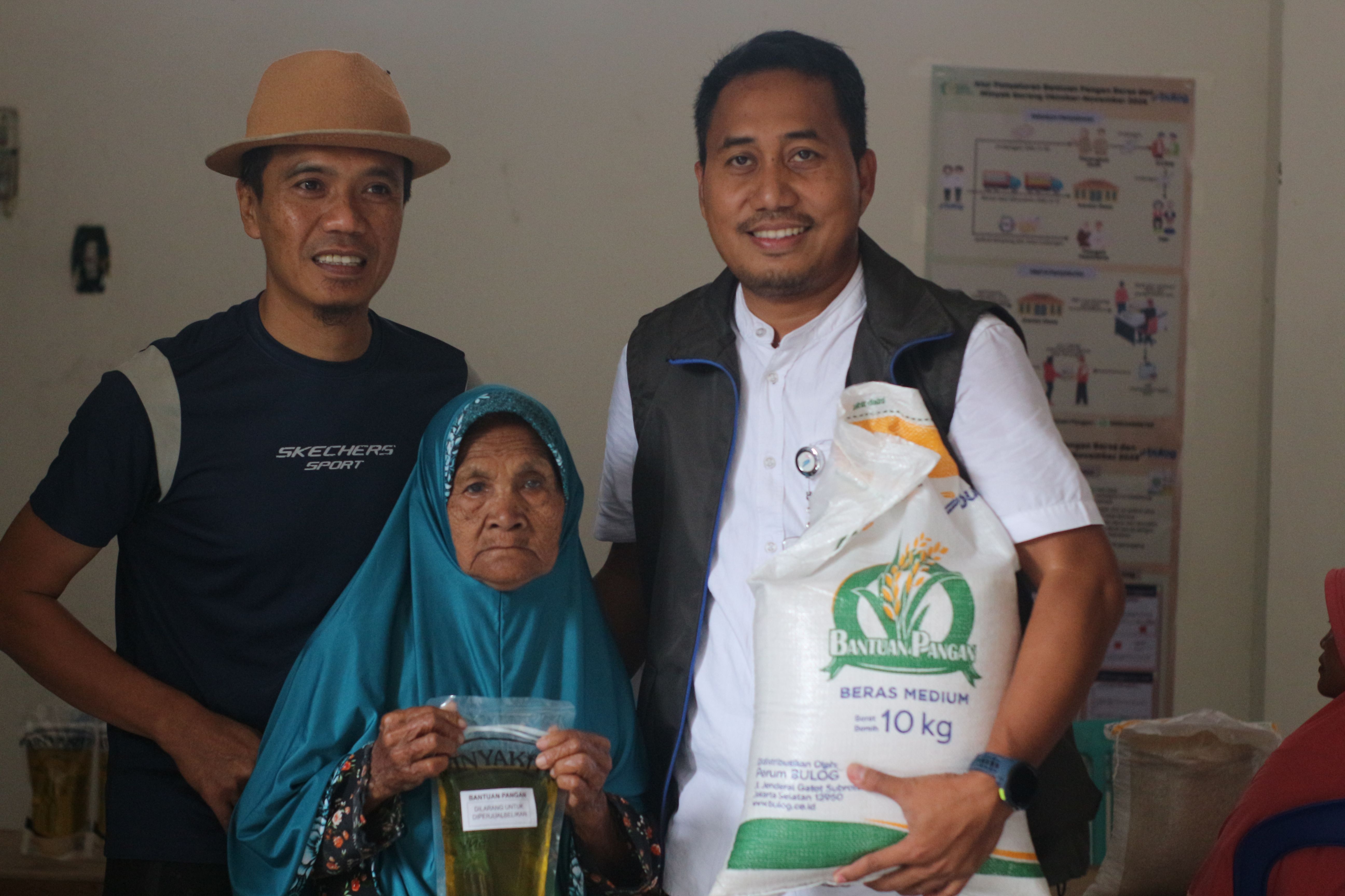 Kepala Bulog Lotim Supermansah (Kanan) bersama Kades Montong Betok (Kiri) Dian AD saat menyerahkan bantuan pangan kedapa masyarakat miskin