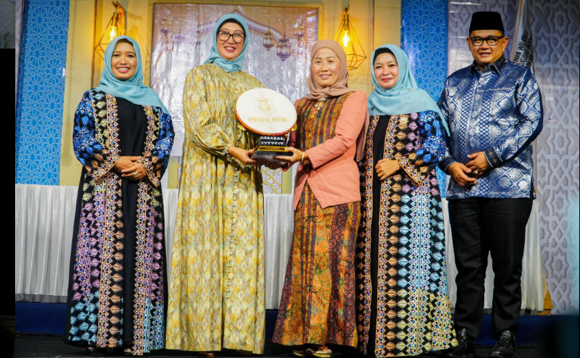 Ketua DPW LASQI NJ NTB Sinta Agathia M. Iqbal menyerahkan Piala Juara Umum kepada Ketua Harian LASQI NJ Kota Mataram Hj. Lale Rasminingsih Alwan Basri pada malam penutupan festival di KLU.