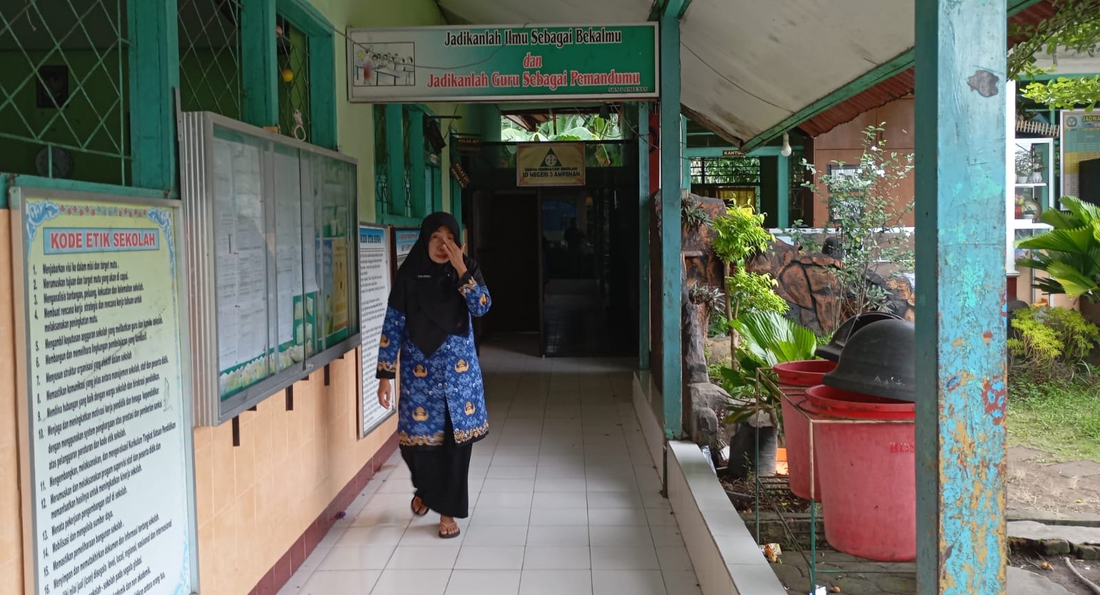 Seorang guru SDN 3 Ampenan berjalan di depan ruang kelas yang akan di rehab, belum lama ini. Rehab sekolah di Mataram dikebut, target rampung akhir 2025.