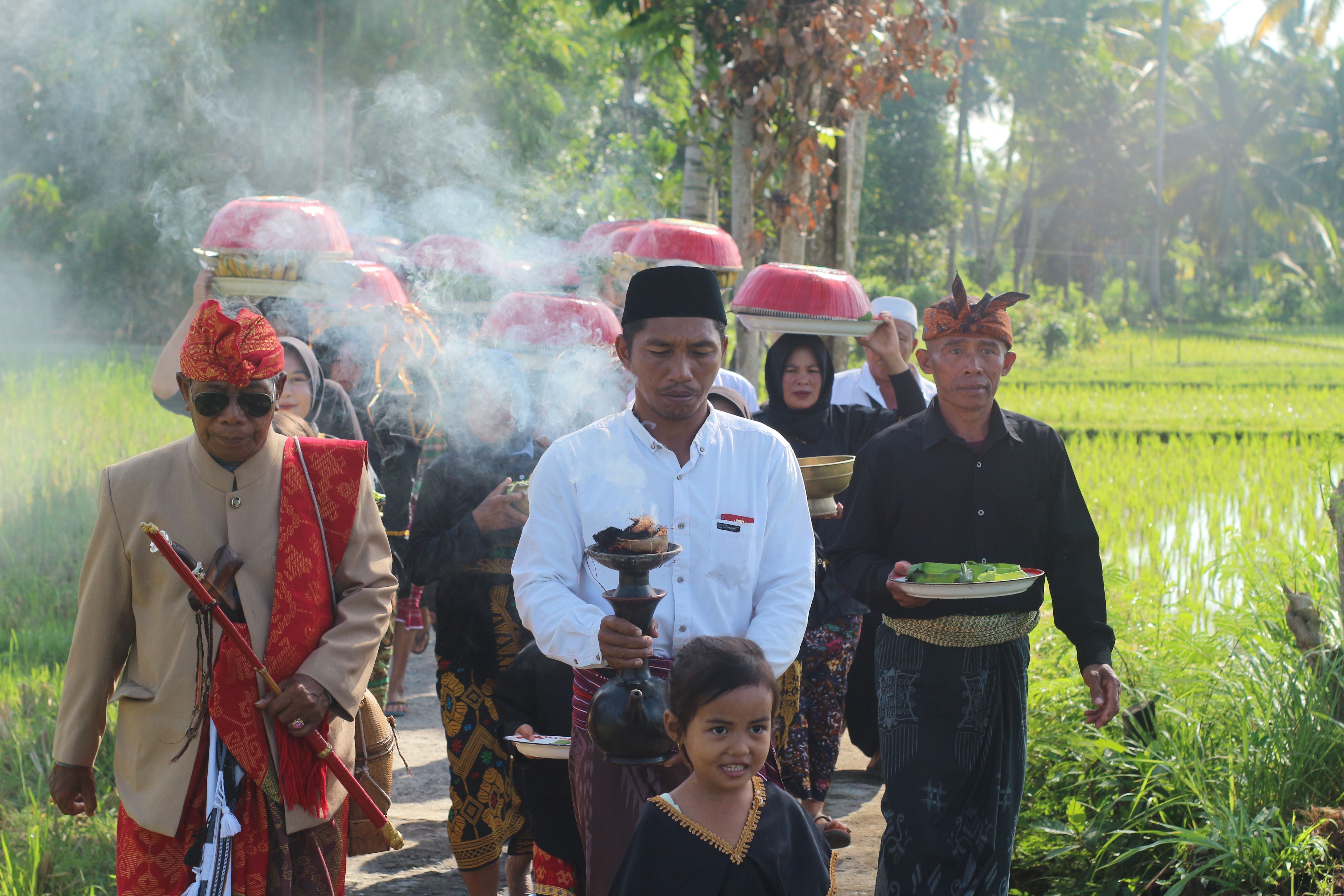 Tokoh adat Desa Kesik saat membawa air suci yang diambil mata air metak, untuk dibawa ke Lingkok ratu lokasi acara puncak gawe desa Nunas Nede.
