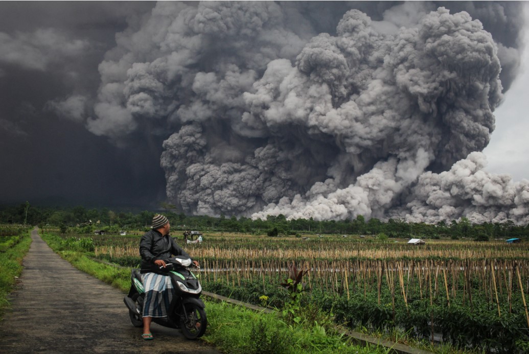 ERUPSI: Seorang pria mengamati aliran piroklastik saat erupsi Gunung Semeru di Lumajang, Jawa Timur, Rabu (19/11).