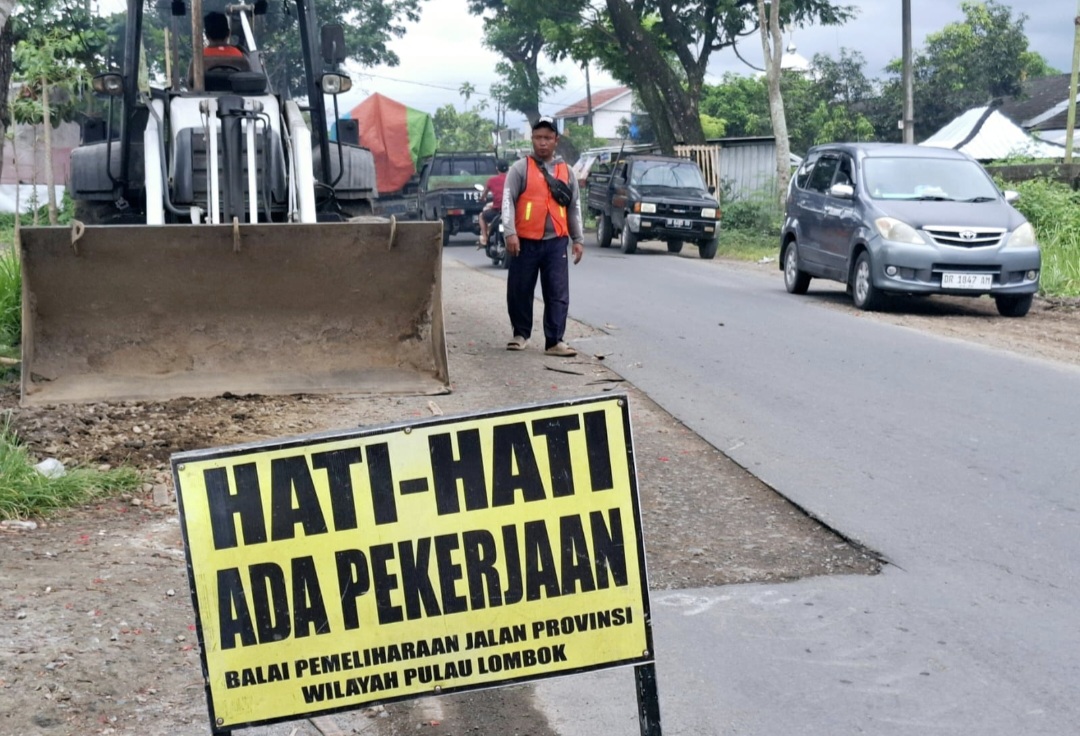Pekerja menggunakan alat berat meratakan hamparan material LPA di atas bongkaran aspal yang rusak berat di Desa Batunyala, Kecamatan Praya Tengah, Rabu (19/11).