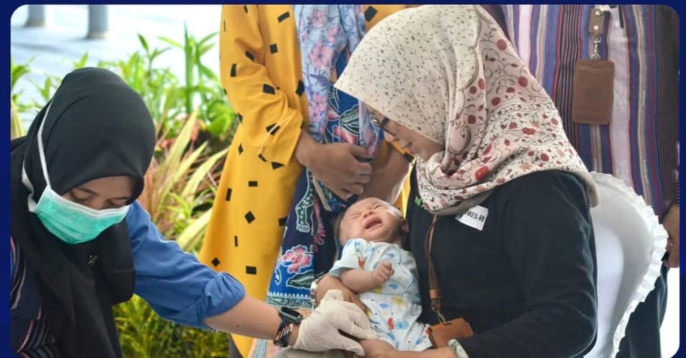 seorang tenaga kesehatan di lotim sedang melakukan vaksin kepada salah seorang bayi