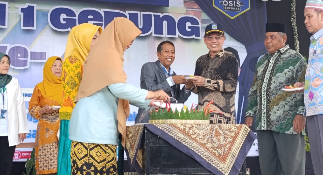 Kepala SMAN 1 Gerung M Ridwan Helmy memberikan tumpeng kepada tamu undangan pada puncak HUT ke-42, Sabtu (21/11). HUT ke-42, SMAN 1 Gerung mantapkan visi mendunia dan perkuat prestasi siswa.