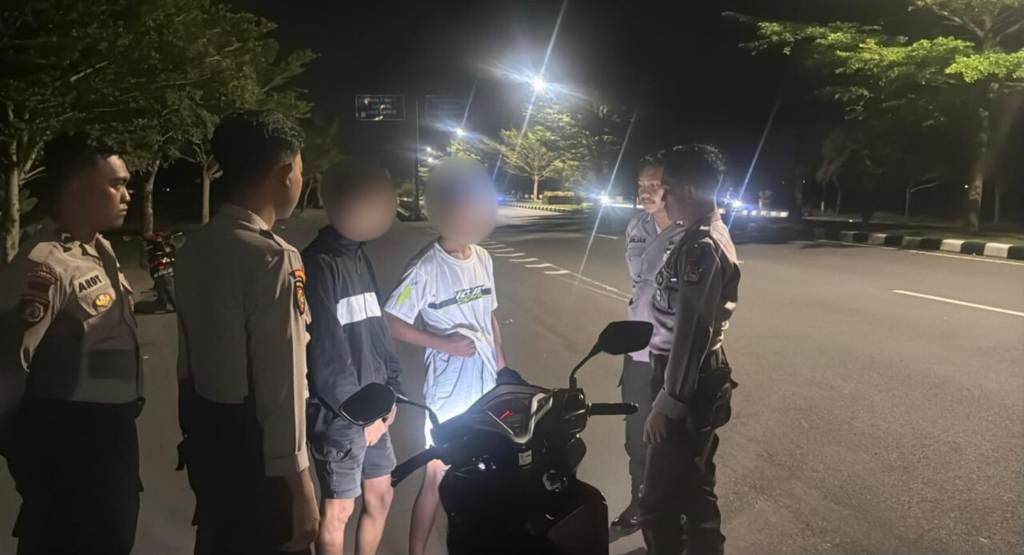 PATROLI: Anggota polisi menginterogasi pemuda yang diduga akan melakukan aksi balap liar di Jalan Lingkar Selatan, Minggu dini hari (23/11).&nbsp;