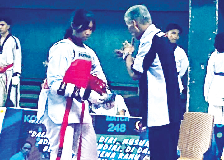 Kepala pelatih Dojang Tegarbaja Sabeum Suhartono Toemiran (kanan) memberikan arahan pada atletnya yang berlaga di Kejurprov Taekwondo NTB 2025.