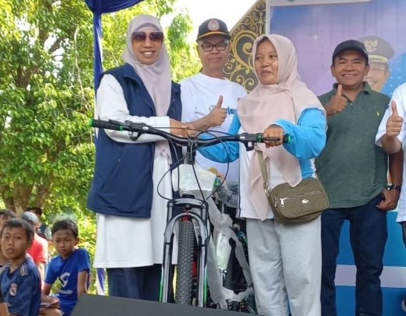 Wabup Lobar Hj Nurul Adha memberikan doorprize pada kegiatan jalan sehat perayaan HUT PGRI ke-80 dan HGN di Taman Kota Gerung, Minggu lalu (23/11). Wabup Lobar tekankan peran guru sebagai teladan.