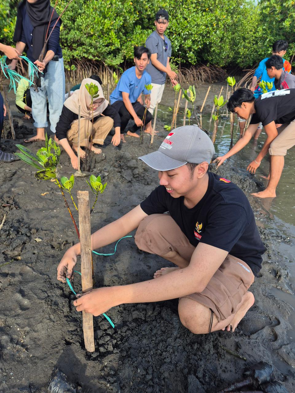 Gusti Bagus Nauval Adifa Suharta menanam mangrove bersama puluhan relawan sebagai upaya melawan pemanasan global.