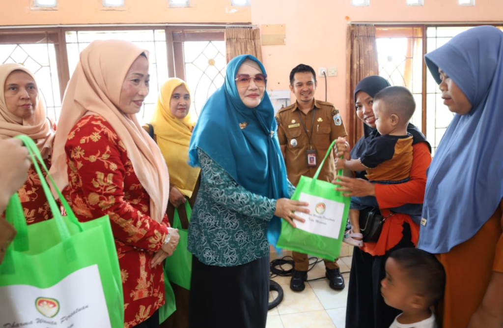 BERBAGI: Penasihat DWP Hj Waridah Mujiburrahman didampingi Ketua DWP Kota Mataram Lale Rasminingsih saat menyalurkan bantuan, Senin (24/11).