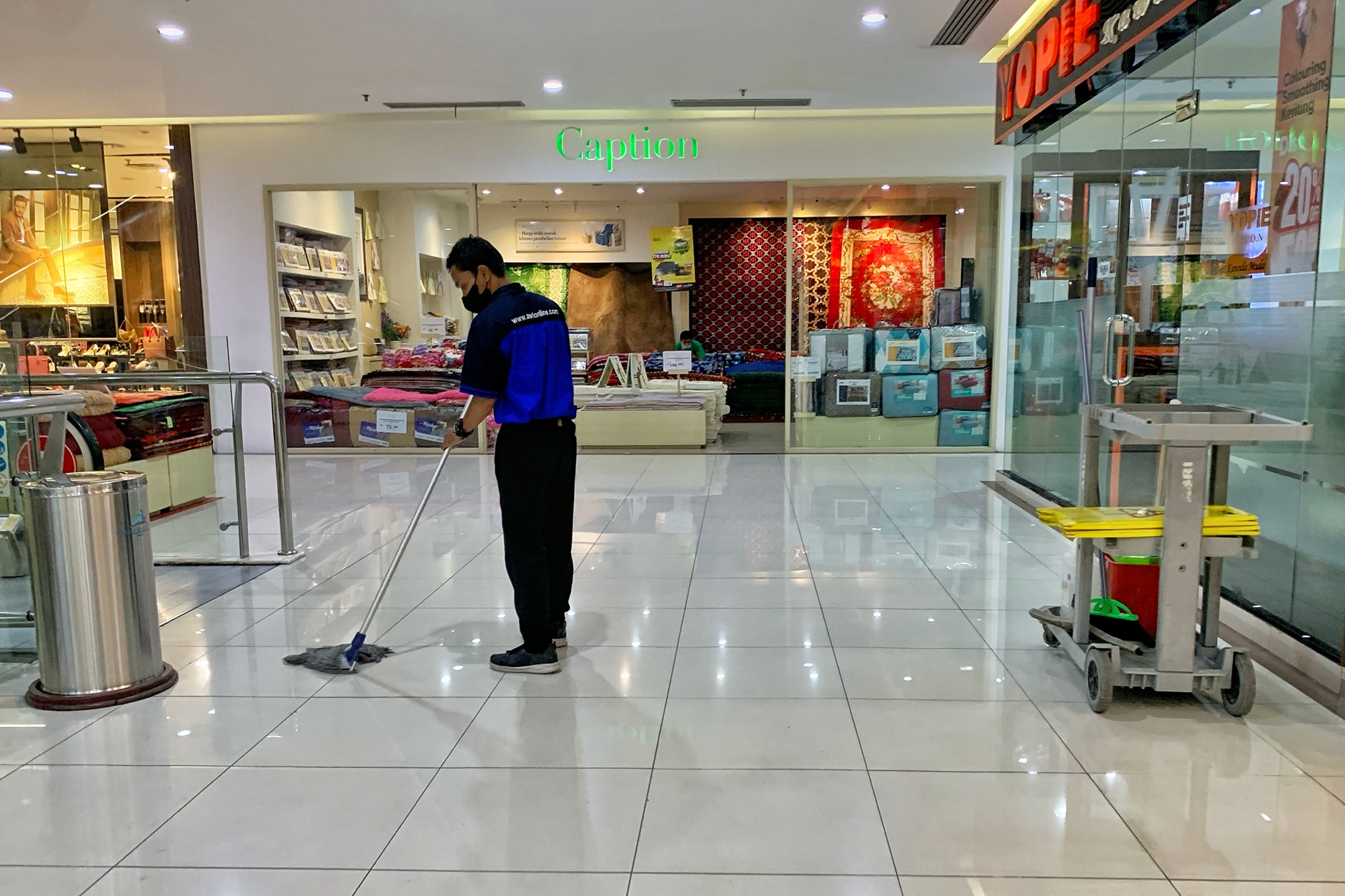 BERSIHKAN LANTAI: Salah satu petugas kebersihan di salah satu pusat perbelanjaan di Kota Mataram, belum lama ini.
