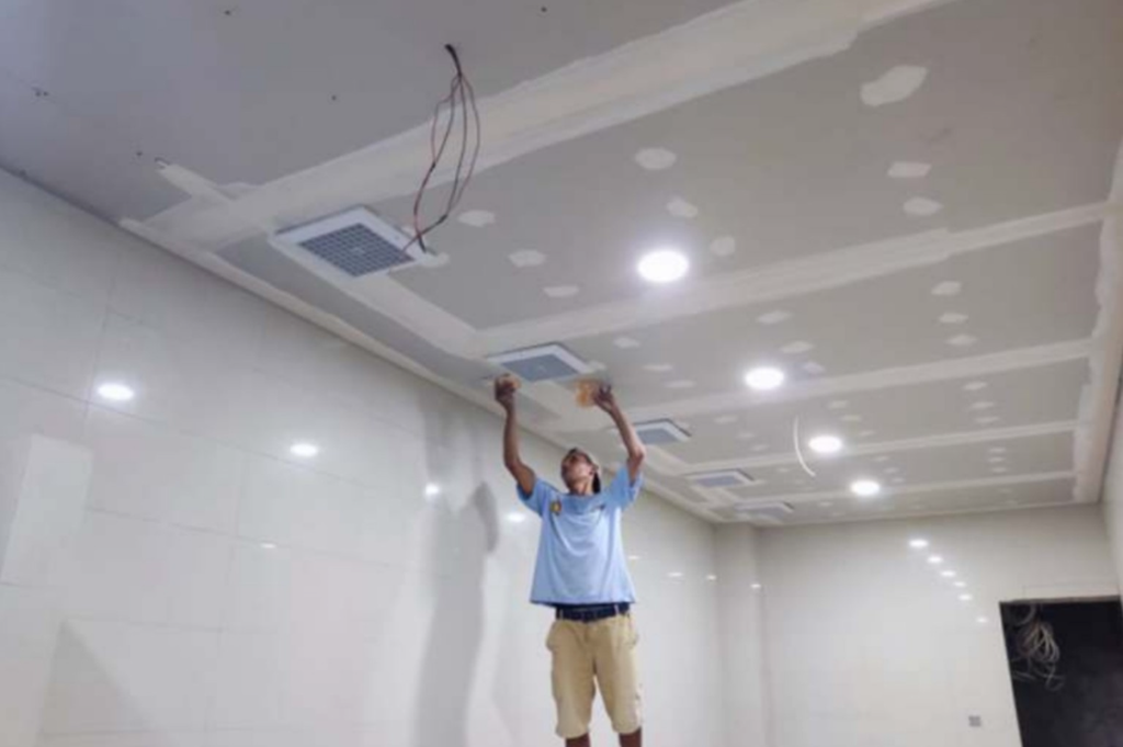 FINISHING INTERIOR: Pekerja menuntaskan pemasangan exhaust fan dan perapian plafon di salah satu ruangan Kantor Wali Kota Mataram yang baru.