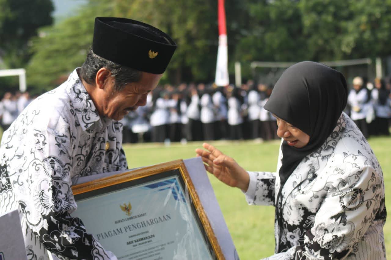 BERI APRESIASI: Wabup Lobar Nurul Adha saat memberikan penghargaan kepada salah satu guru saat upacara peringatan Hari Guru Nasional, Selasa (25/11).
