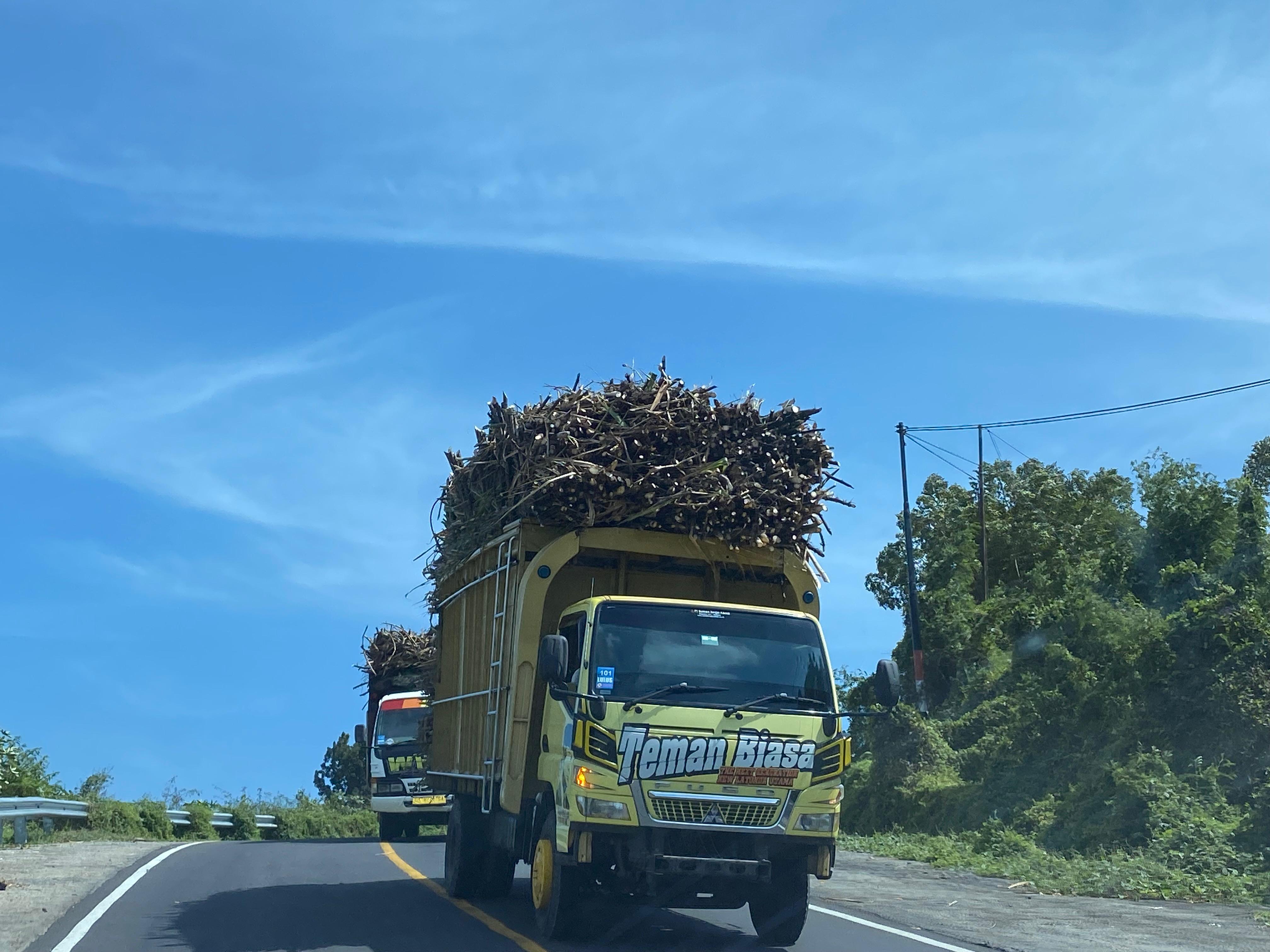 SARAT MUATAN: Truk pembawa hasil panen petani tebu di Dompu melintasi jalan raya menuju gudang pabrik.