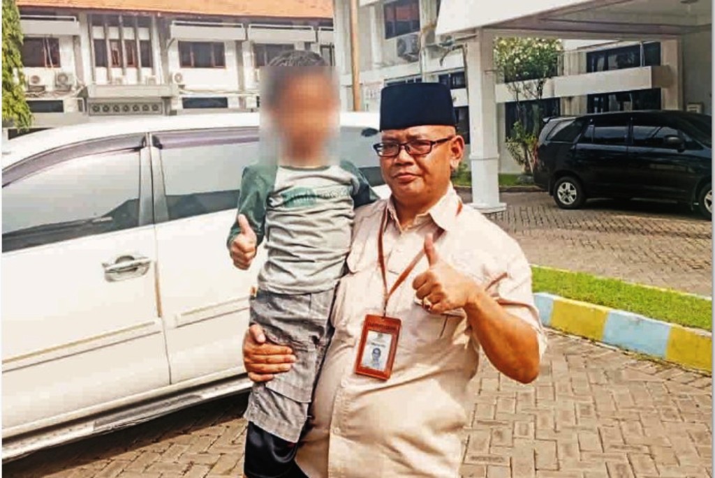 PENDAMPINGAN: Salah seorang petugas Dinsos Gresik saat membawa bocah yang digadaikan ayahnya ke Rumah Aman Dinsos untuk menjalani asesmen.