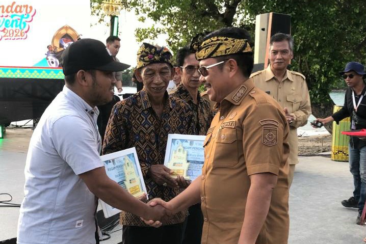 TERIMA PENGHARGAAN: Kepala Desa Sedau Amir Syarifudin saat menerima penghargaan juara I Lomba Desa Wisata 2025 dari Bupati Lombok Barat Lalu Ahmad Zaini.