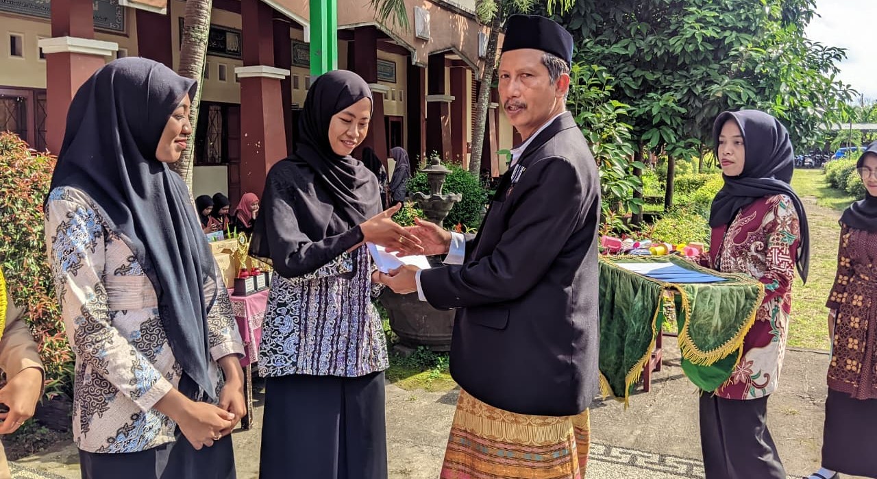 Kepala MAN Lobar H Abdul Azis Faradi memberikan penghargaan kepada guru berprestasi pada peringatan HGN 2025 di madrasah setempat, Selasa (25/11).