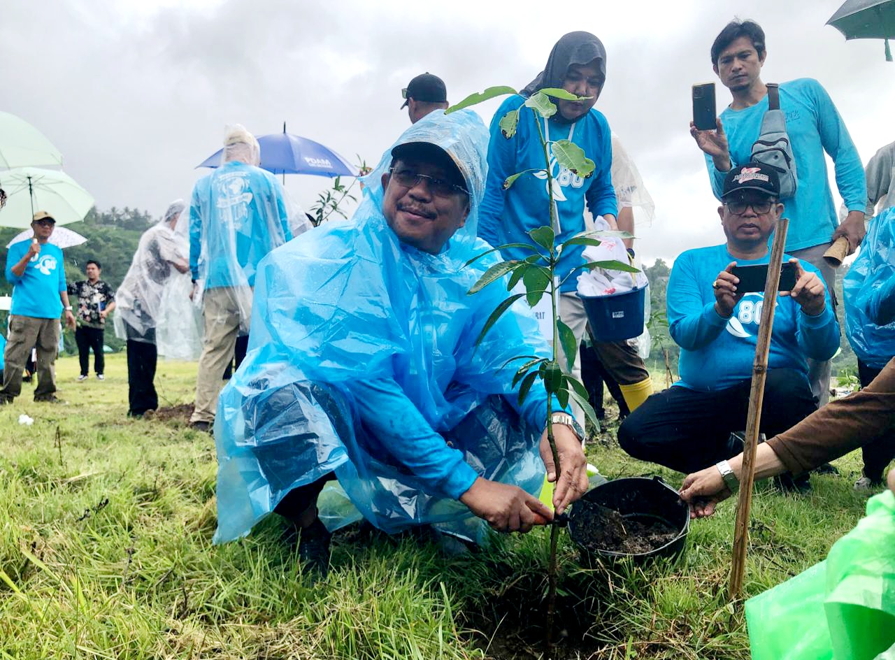 TETAP SEMANGAT: Bupati Lombok Barat Lalu Ahmad Zaini saat menanam pohon dalam peringatan Hari Bhakti PU ke-80 di kawasan Bendungan Meninting, Kamis (27/11).