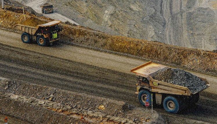 HASIL BUMI: Dua truk sedang beroperasi di area tambang milik PT AMNT.