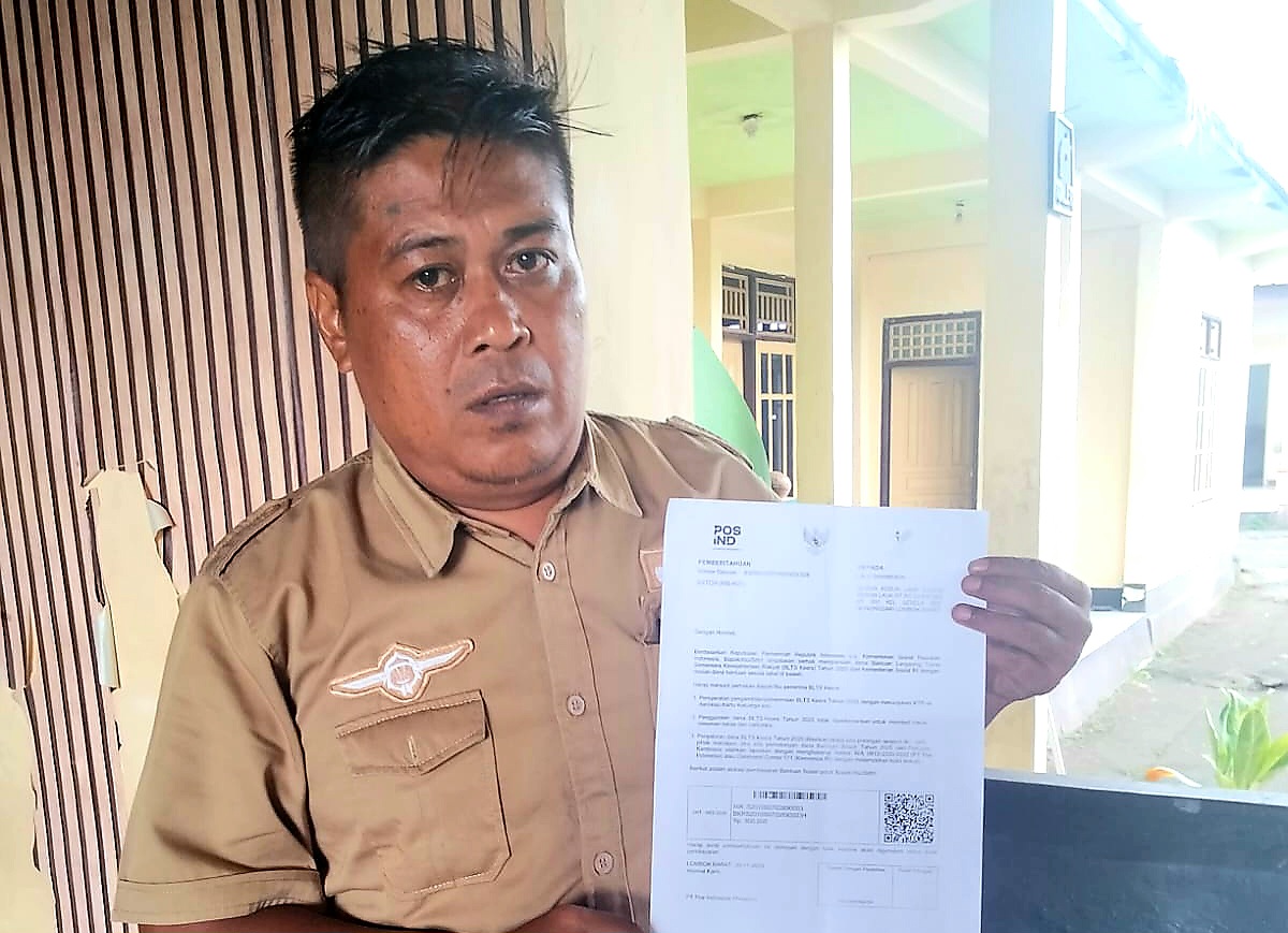 TUNJUKKAN SURAT: Kepala Desa Sesela Taufik menunjukkan surat undangan penerima bantuan BPNT ke warga yang justru dinilai memiliki ekonomi menengah ke atas. &nbsp;