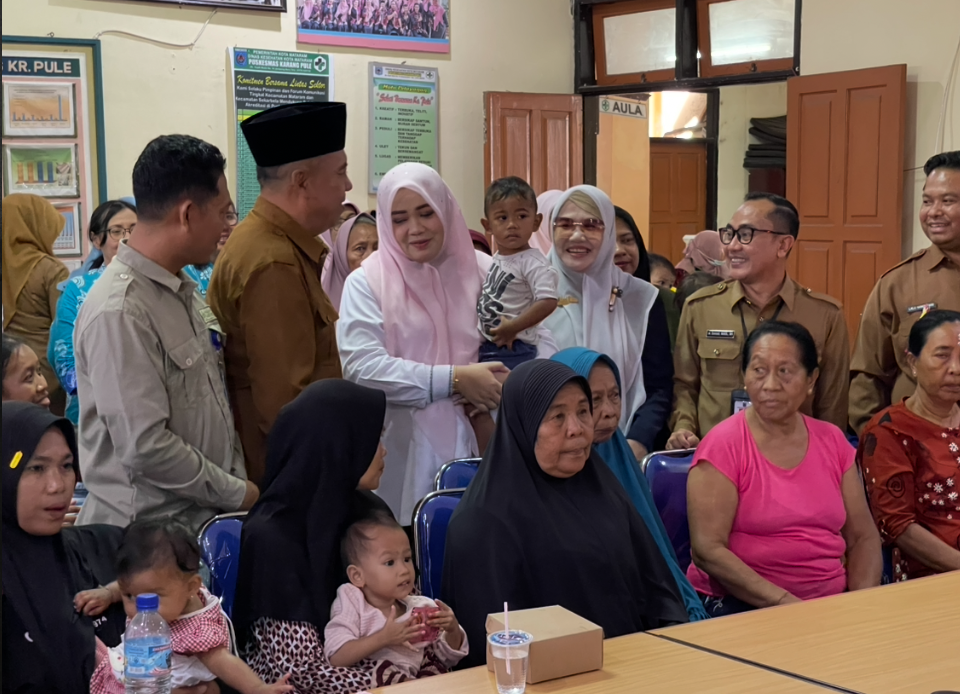 Wabgub Umi Dinda menggendong balita salah satu warga Karang Pule.