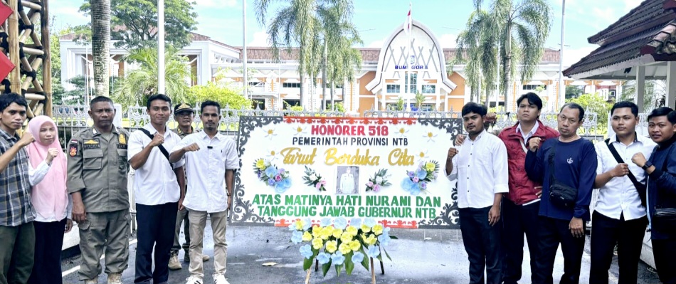 Para tenaga honorer membawa karangan bunga