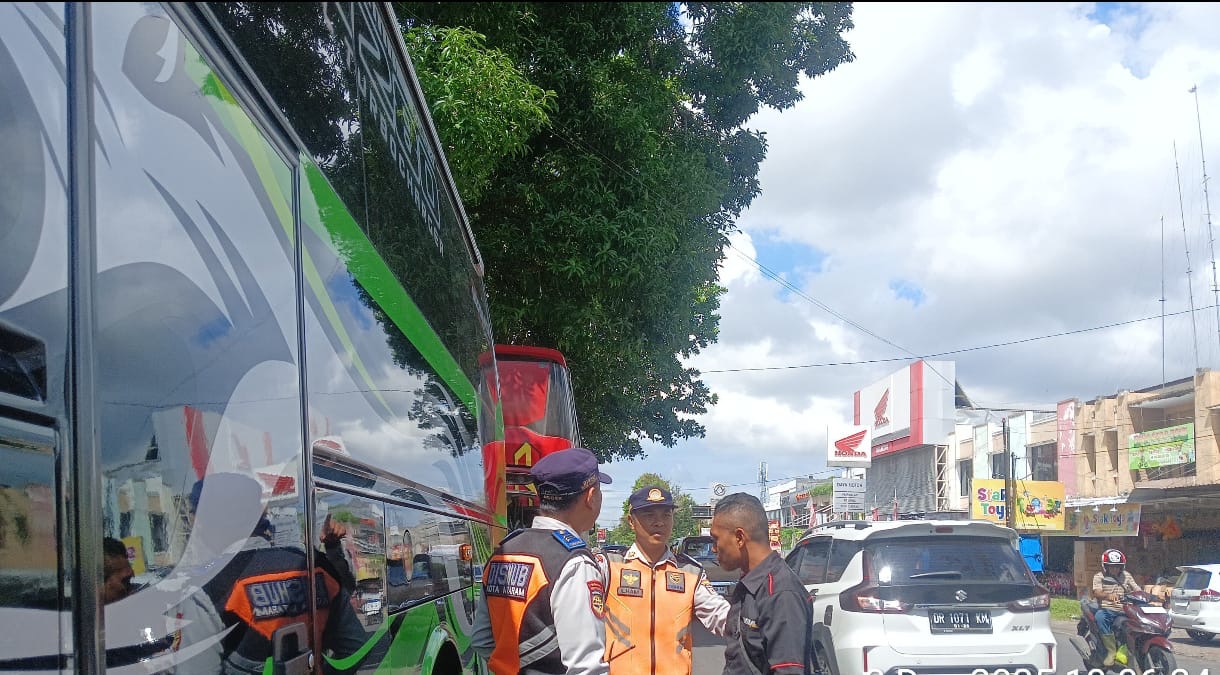 Petugas Dishub Kota Mataram menegur salah satu sopir bus yang parkir sembarangan di ruas kota.