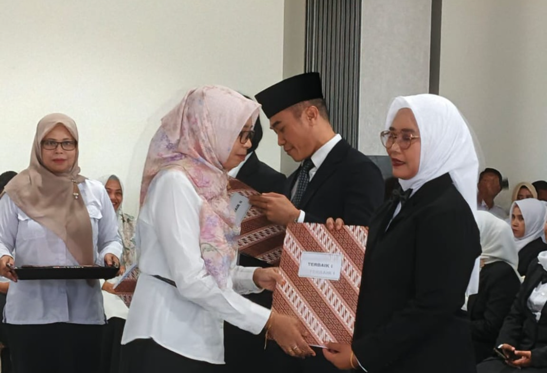 Baiq Baktiyanti menerima piagam penghargaan Terbaik I langsung dari Kepala BPSDMD NTB Baiq Nelly Yuniarti.