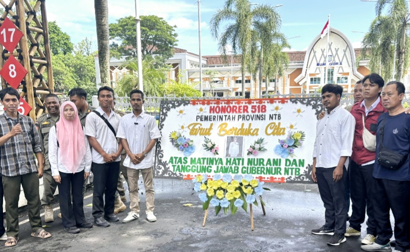 Para tenaga honorer membawa karangan bunga