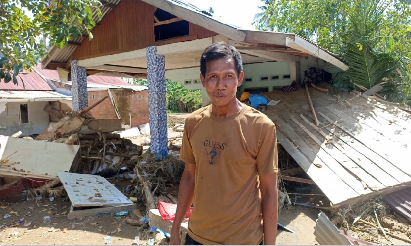 PENGALAMAN MENEGANGKAN: Fernandi di depan rumahnya yang hancur karena banjir di Kampung Apar, Kota Padang, Sumbar, (2/12).
