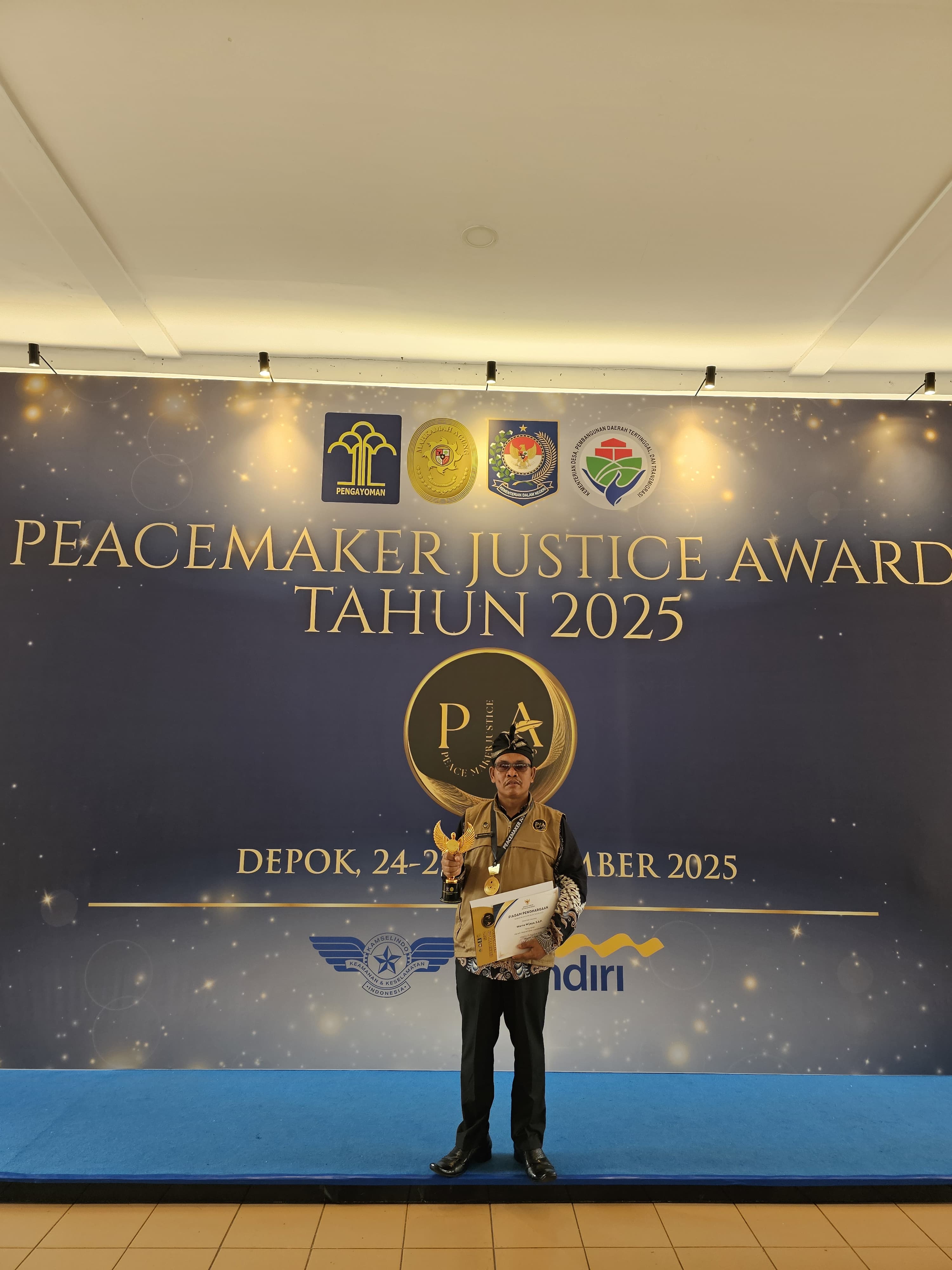 DESA HARMONI: Kepala Desa Bentek Warna Wijaya menunjukkan piagam penghargaan yang diterimanya atas keberhasilan berprestasi di tingkat nasional