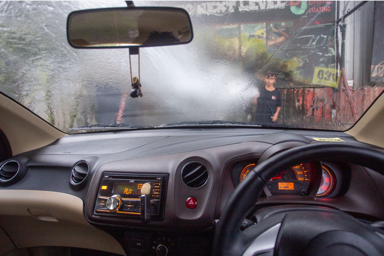 BIAR KINCLONG: Seorang karyawan DJ2 Crystal Coating sedang menyemprot mobil untuk dicuci di Jalan Lingkar Selatan, Jempong Baru, Kota Mataram.