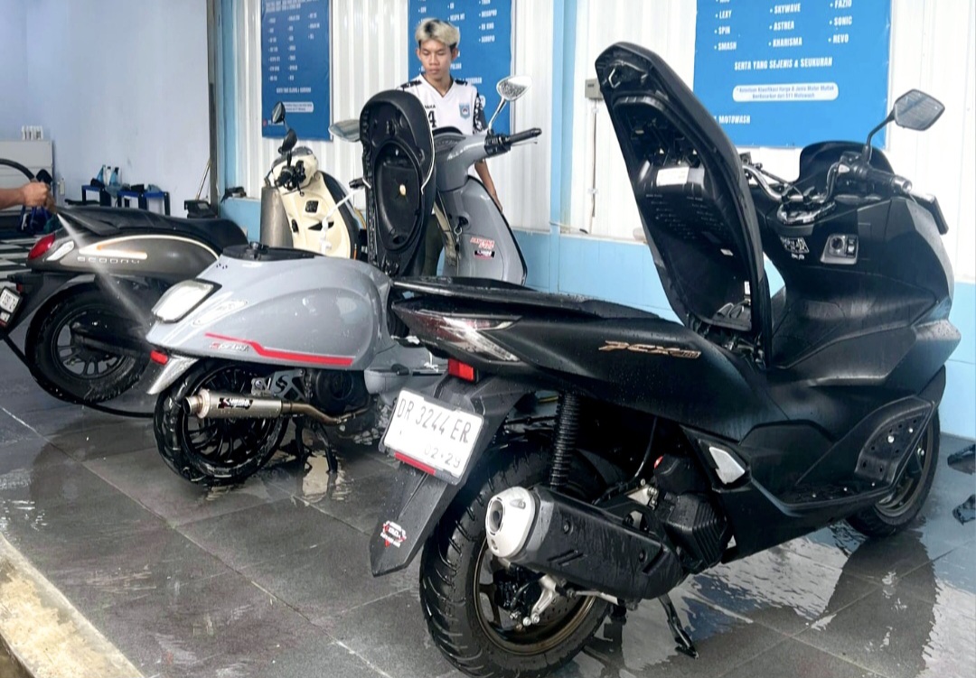 Petugas membersihkan motor pelanggan di lokasi cuci motor di Jalan Arif Rahman Hakim, Kota Mataram, Jumat (5/12). Lokasi ini jadi satu dengan barbershop Sweet Java.