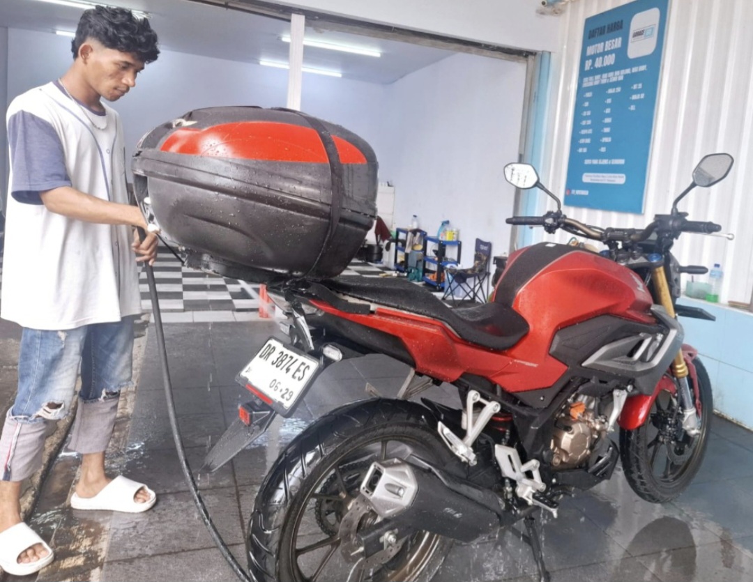 Petugas mencuci sepeda motor di Jalan Arif Rahman Hakim, Kota Mataram. Area ini jadi satu dengan lokasi barbershop Sweet Java.