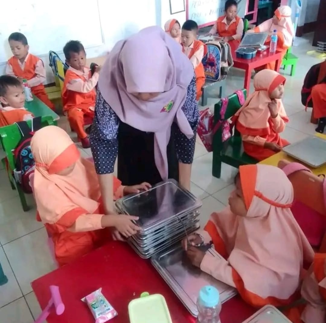 BAGIKAN MBG: Seorang guru membagikan MBG ke siswa PAUD. Program Makan Bergizi (MBG) yang digulirkan pemerintah mendapat respons sangat positif, khususnya dari lembaga pendidikan anak usia dini.