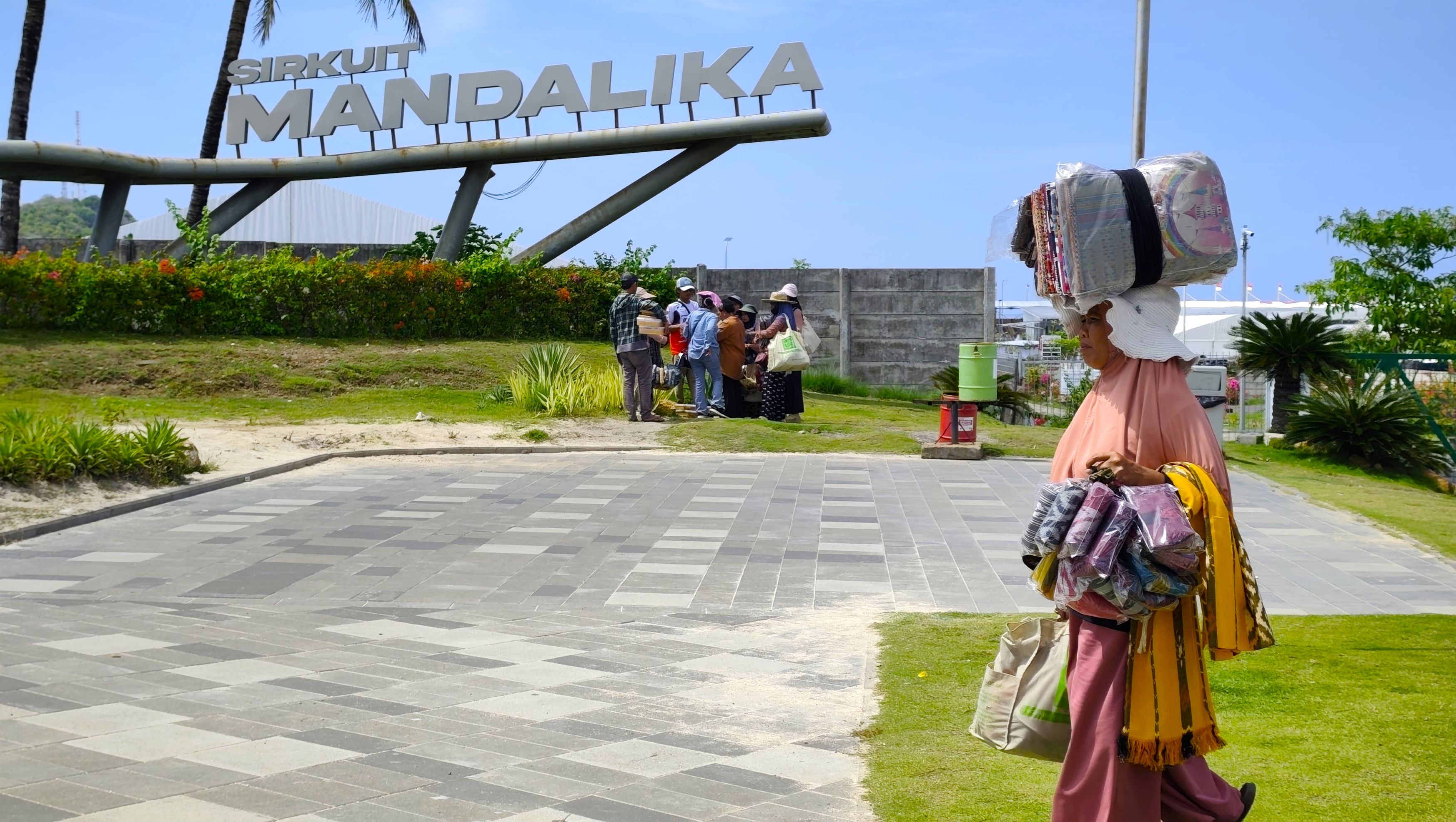 Seorang pedagang kain melintas di depan area Sirkuit Internasional Mandalika, Lombok Tengah, belum lama ini.