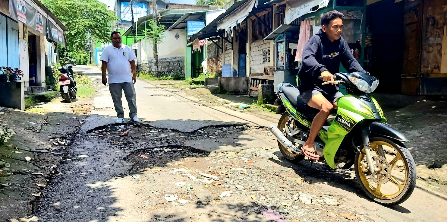 RUSAK PARAH: Kepala Desa Langko, Mawardi menunjukkan jalan rusak parah, Minggu (7/12).