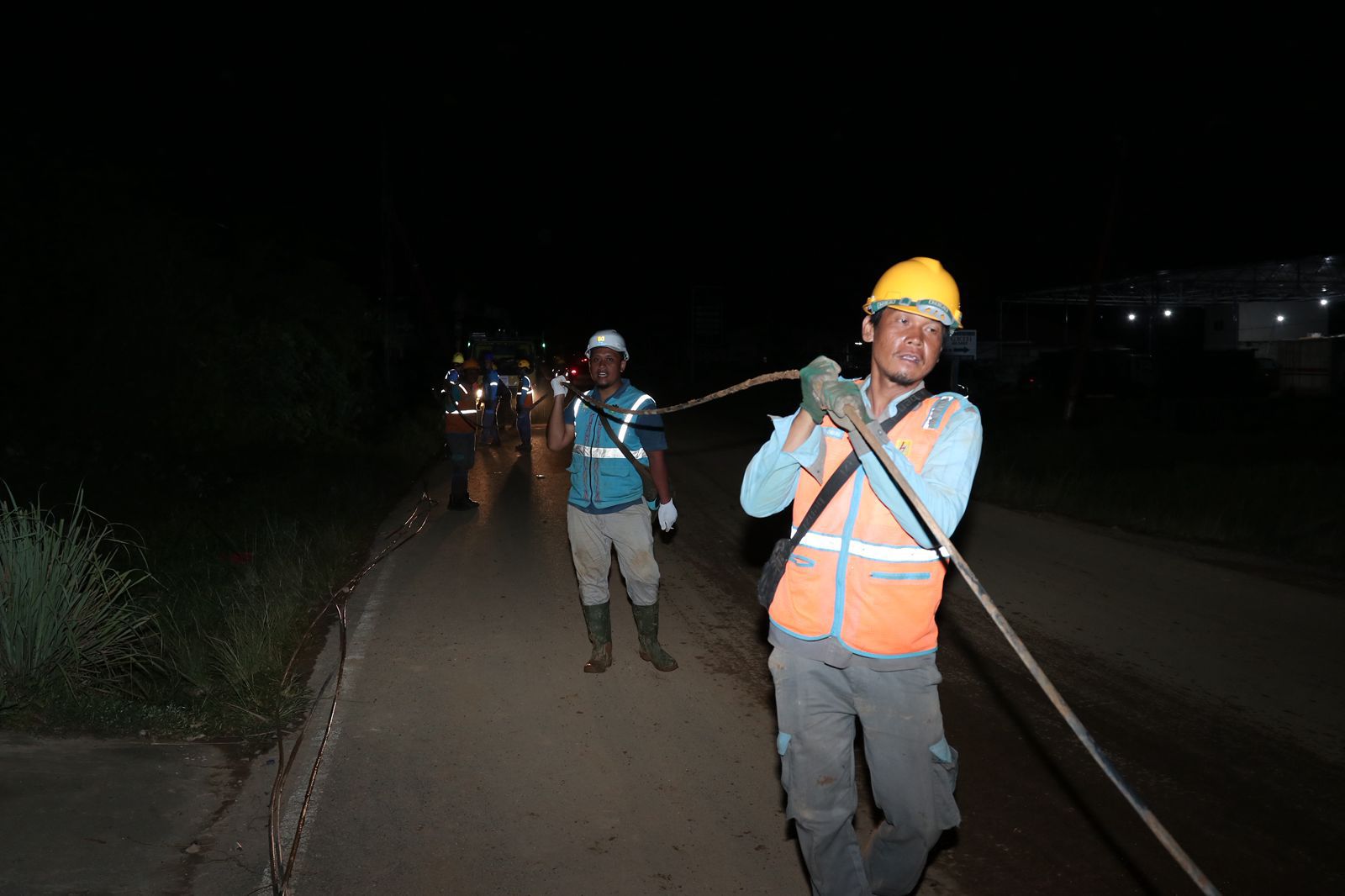 Petugas PLN melakukan penarikan jaringan listrik di tengah kegelapan untuk memulihkan pasokan listrik yang terdampak di Tapanuli Tengah.