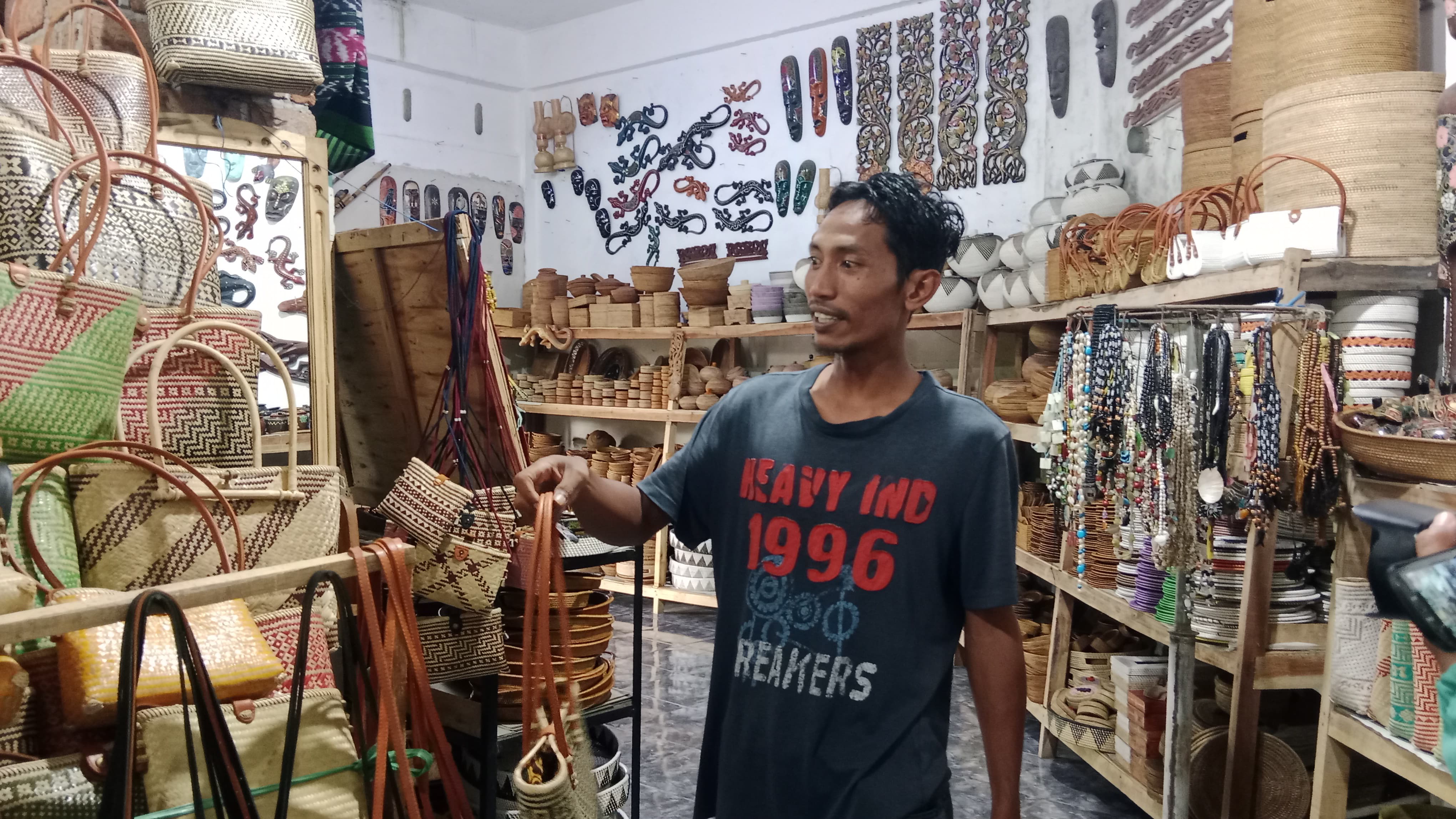 EKONOMI LOKAL: Lalu Sopiandi saat menunjukkan sejumlah kerajinan bambu khas Desa Loyok di artshop miliknya, Senin (8/12)