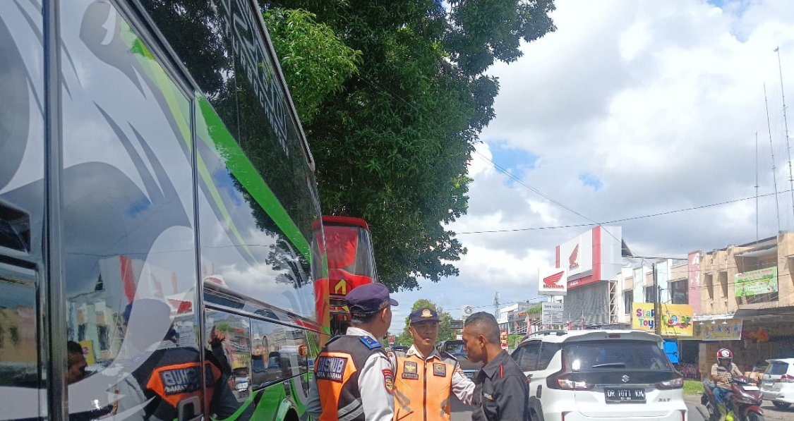 Dua petugas dari Dishub Kota Mataram menegur seorang sopir bus yang parkir sembarangan di bahu jalan.