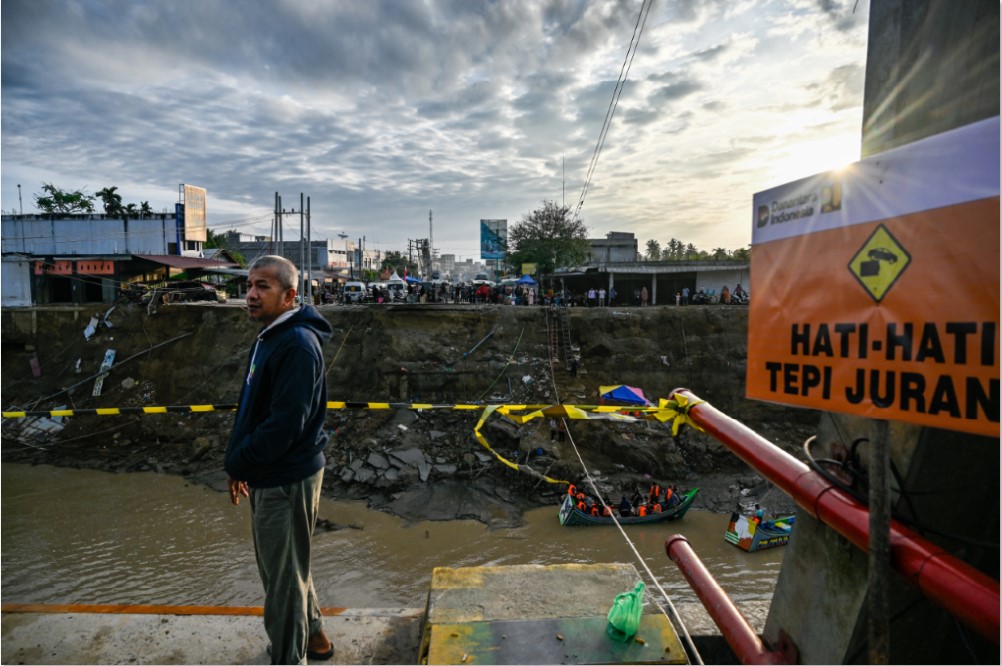 AKSES TERPUTUS: Seorang pria berdiri di dekat jembatan runtuh di atas Sungai Peusangan di Kuta Blang, Kabupaten Bireuen, Provinsi Aceh, Indonesia, Selasa (9/12).