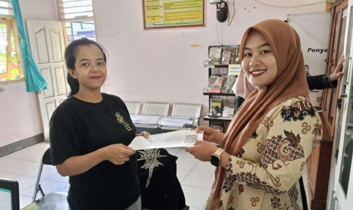 Petugas menyerahkan berkas administrasi kependudukan kepada warga saat pelaksanaan Politeknik Dukcapil di salah satu kelurahan di Kota Mataram, Selasa (9/12).