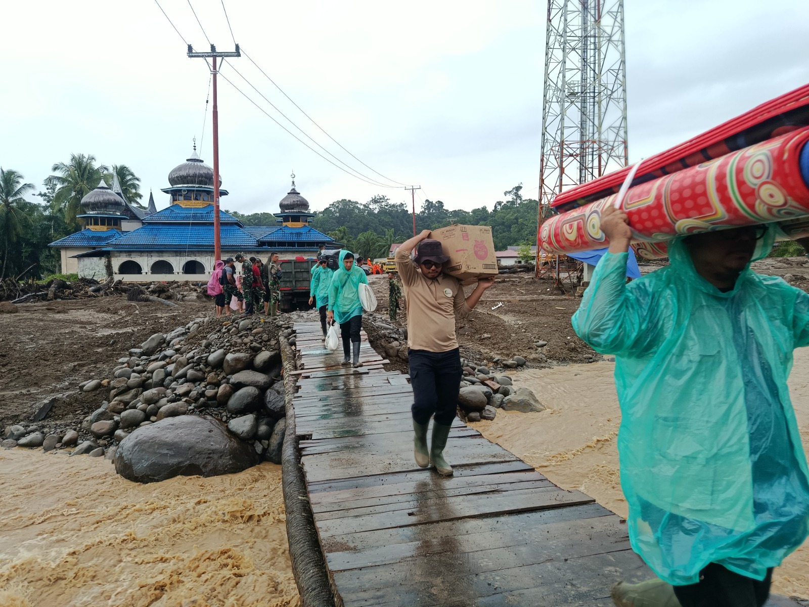 Pendistribusian logistik melalui jembatan darurat yang menghubungkan Jorong kayu Pasak Tengah dan daerah Sikabau Jorong Kayu Pasak Selatan, Nagari Salareh Aia, Kecamatan Palembayan, Kabupaten Agam.