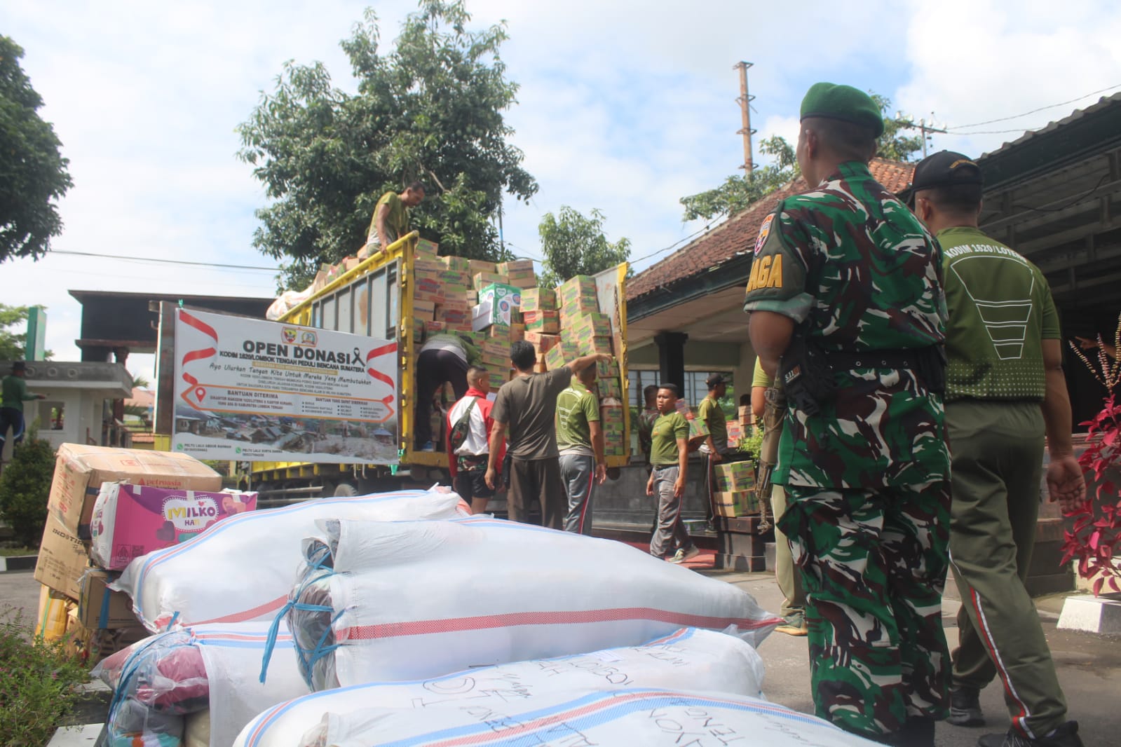 PEDULI SESAMA: Para prajurit TNI berjibaku mengangkut ribuan dus dan karung berisi bantuan untuk para korban bencana Sumatera dan Aceh di halaman Makodim 1620/Loteng, Jumat (12/12).