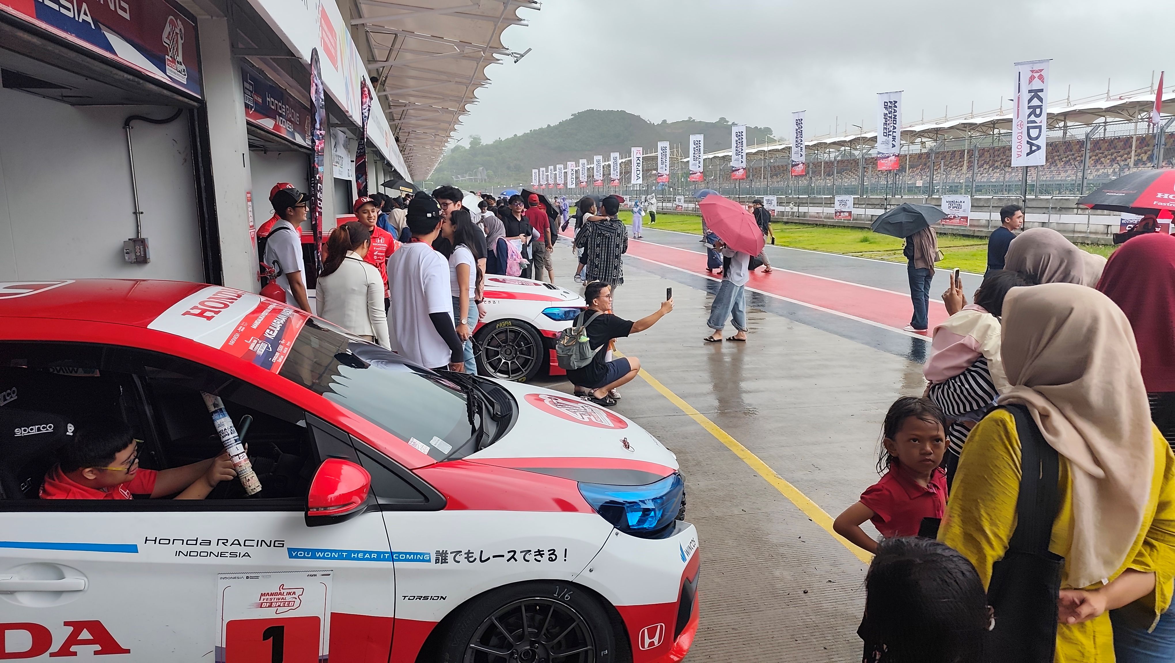 Para penonton tetap bersemangat mengikuti sesi pitwalk pada rangkaian ajang Mandalika Festival of Speed 2025 putaran akhir di Sirkuit Internasional Mandalika, Loteng, Minggu (14/12).