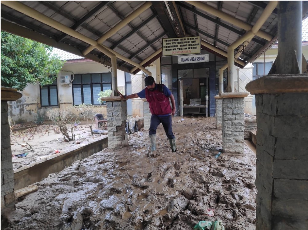 Petugas membersihkan lorong RSUD Aceh Tamiang yang dipenuhi lumpur.