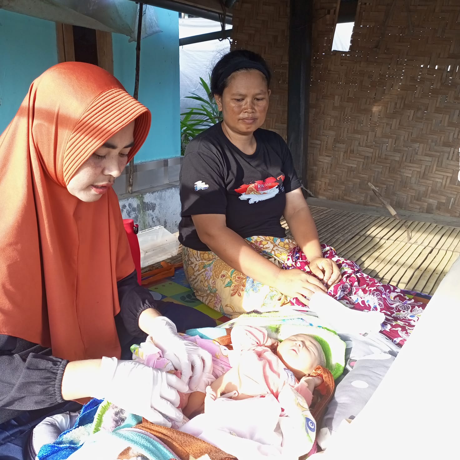 Fitriwani seorang bidan desa di kecamatan Sembalun saat memeriksa kesehatan seorang bayi di salah satu Dusun terpencil di Kecamatan Sembalun.