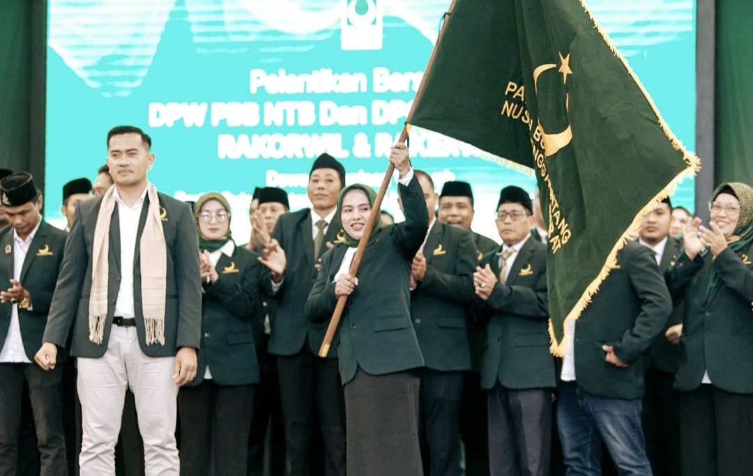 Ketua DPW PBB NTB Nadirah Al-Habsy mengibarkan pataka usai dilantik Ketua Umum PBB Gugum Ridho Putra di Hotel Lombok Raya Mataram, Senin (15/12).