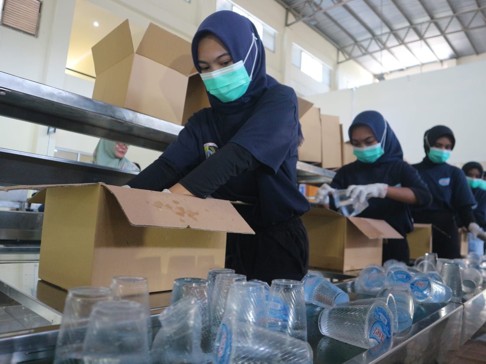 PRODUKSI AMDK: Sejumlah tengah kerja PT Energi Selaparang saat mengemas AMDK  merek Asel yang baru saja selesai diproduksi, beberapa waktu lalu.