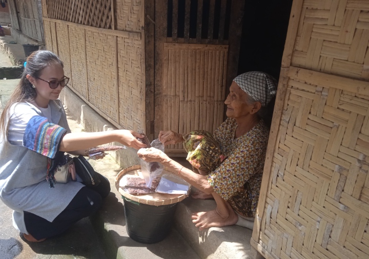 Seorang wisatawan berbelanja camilan yang dijual seorang nenek di Kampung Sasak Ende.